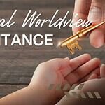 Hand passing a key symbolizing inheritance over a wooden table.